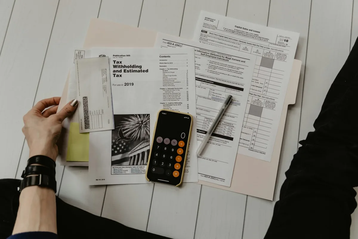 Documentos y calculadora sobre un escritorio listos para un trámite
